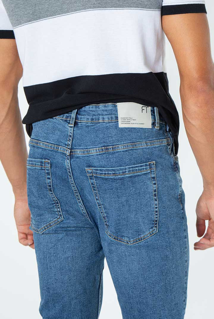 alt="Francisco Tolli med blue carrot denim jeans back view"